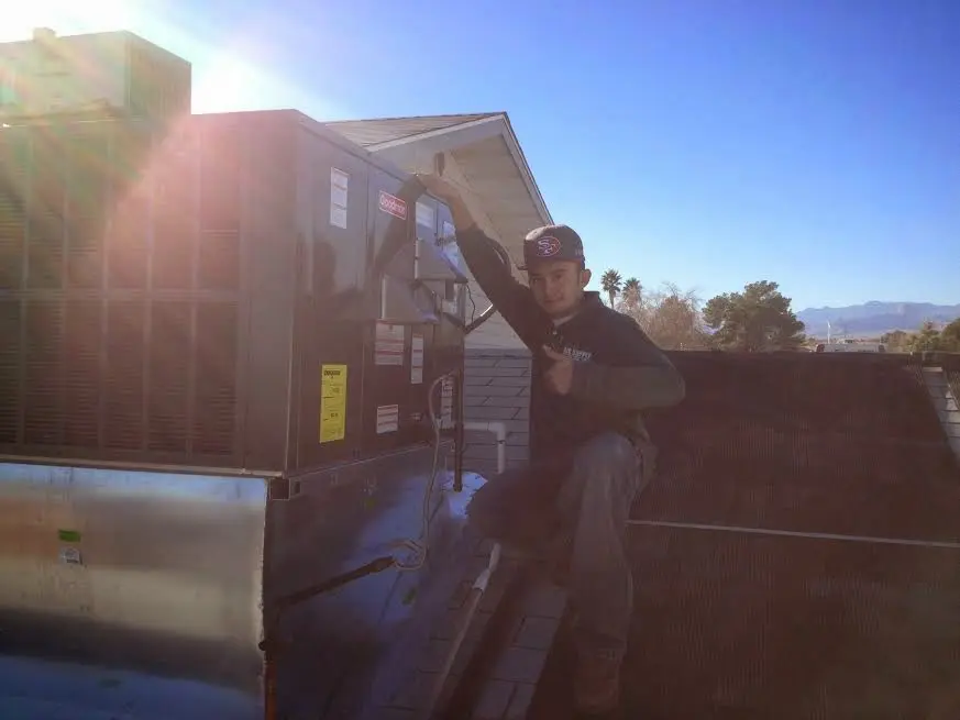 HVAC technician performing HVAC Inspection on a rooftop unit in Marshfield
